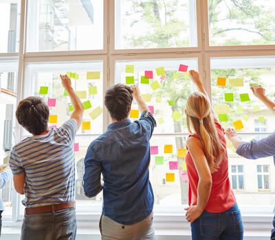 Des personnes posent des post-its.